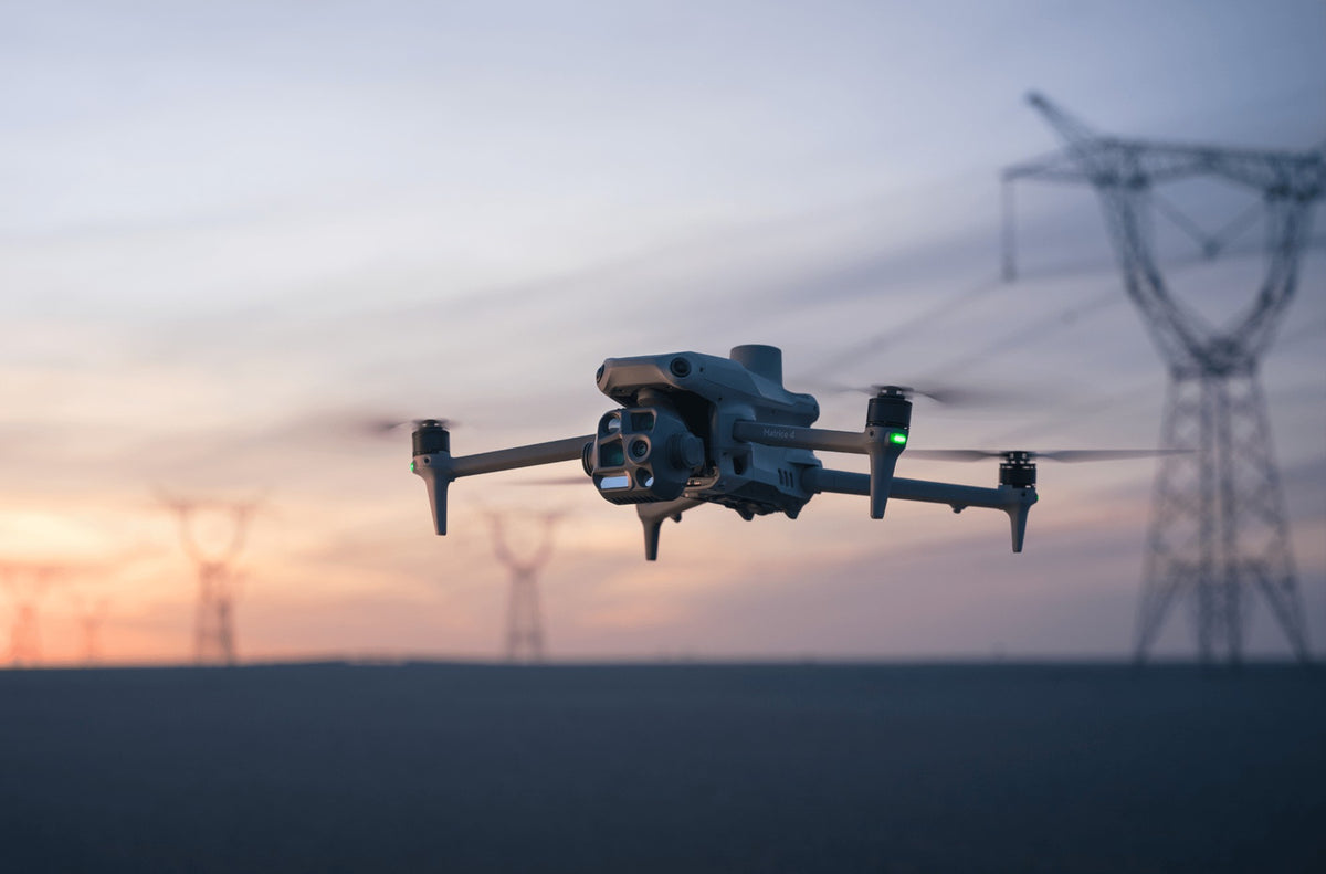 Dron DJI Matrice 4 w locie nad liniami energetycznymi o zachodzie słońca